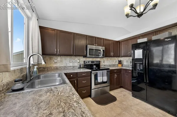 a kitchen with stove a sink and refrigerator