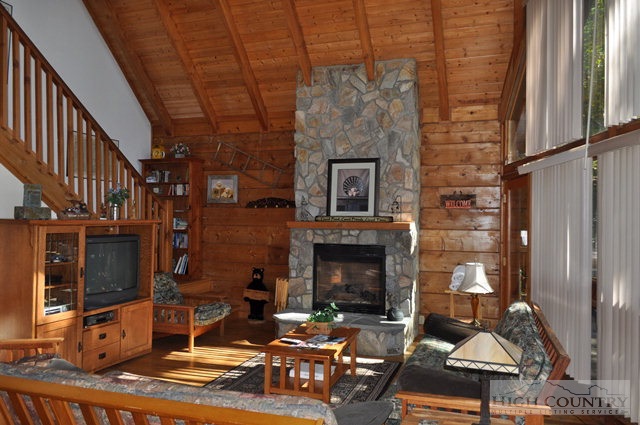 346-348 Grady Winkler Road Boone, NC 28607 - Photo 23 of 32 a living room with furniture a fireplace and a floor to ceiling window