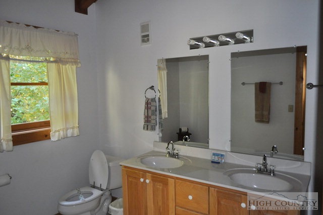 346-348 Grady Winkler Road Boone, NC 28607 - Photo 30 of 32 a bathroom with a double vanity sink toilet and mirror
