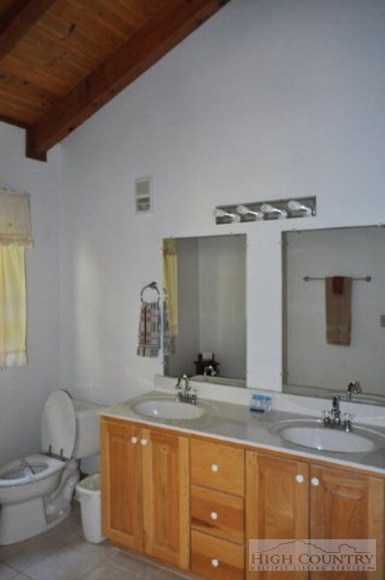 346-348 Grady Winkler Road Boone, NC 28607 - Photo 31 of 32 a bathroom with a granite countertop sink a toilet and a mirror