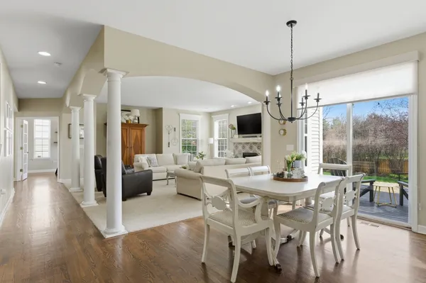 a view of a dining room and livingroom with furniture wooden floor a chandelier