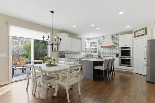 a view of a dining room and livingroom with furniture wooden floor a chandelier