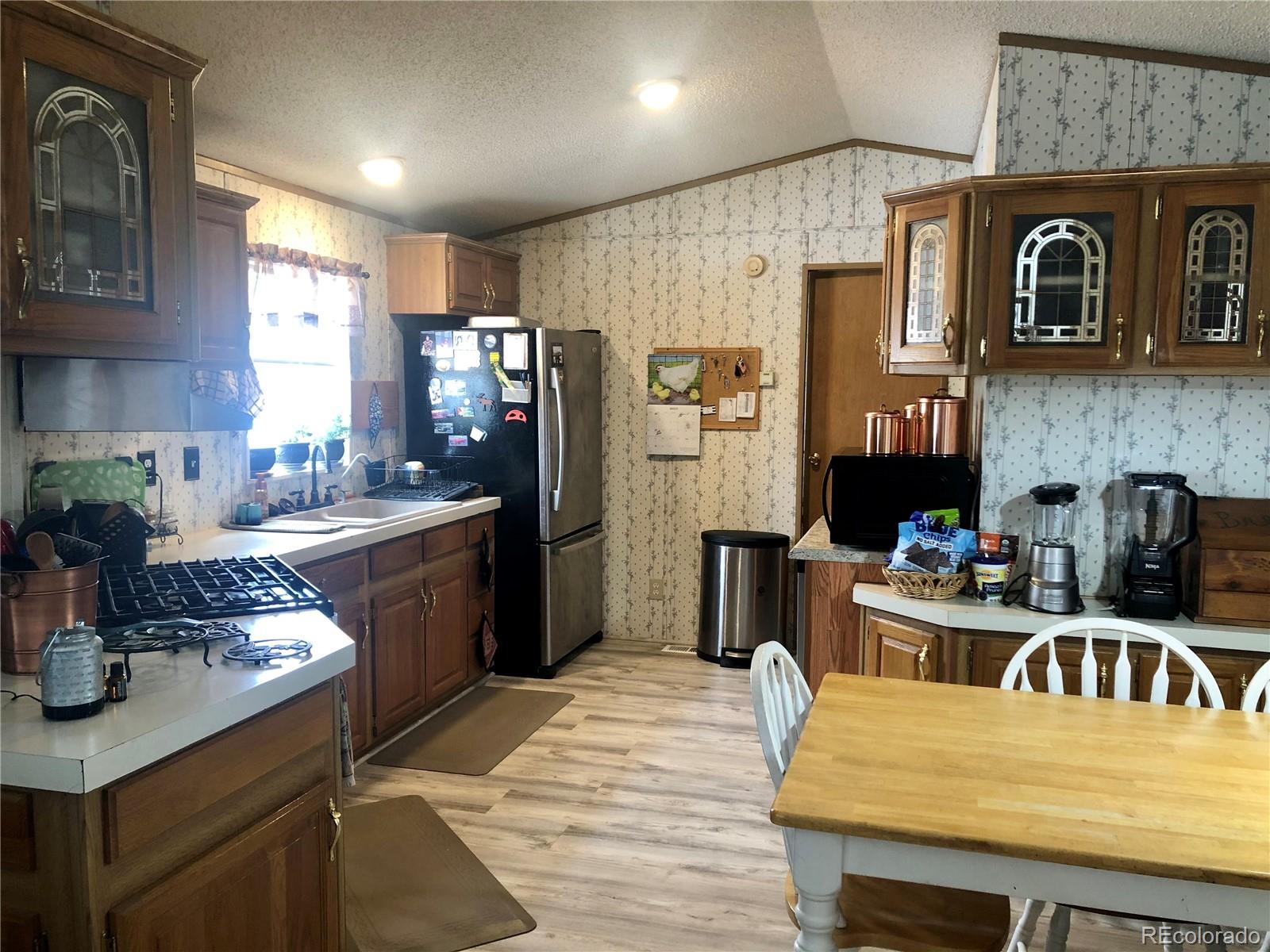 59501 County Rd GG Moffat, CO 81143 - Photo 5 of 25 a kitchen with stainless steel appliances granite countertop a sink a stove and refrigerator