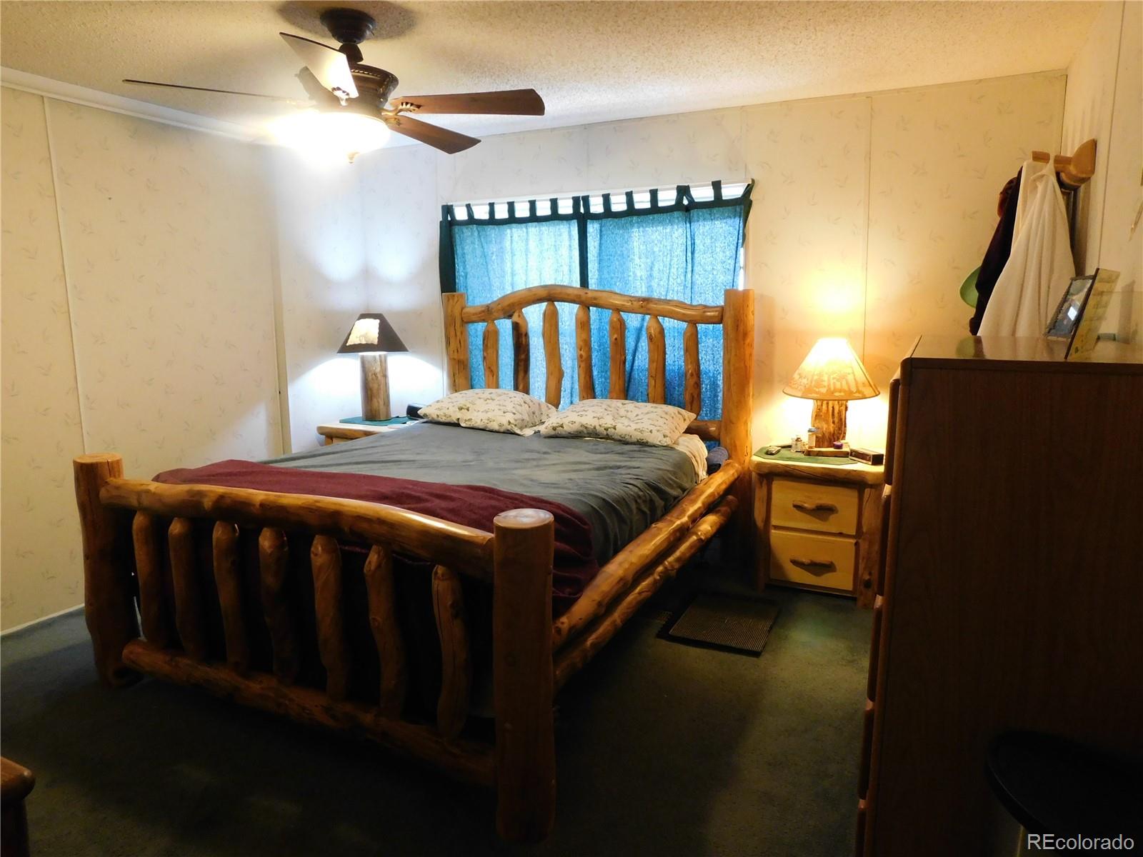 59501 County Rd GG Moffat, CO 81143 - Photo 7 of 25 a bedroom with a bed and a chandelier