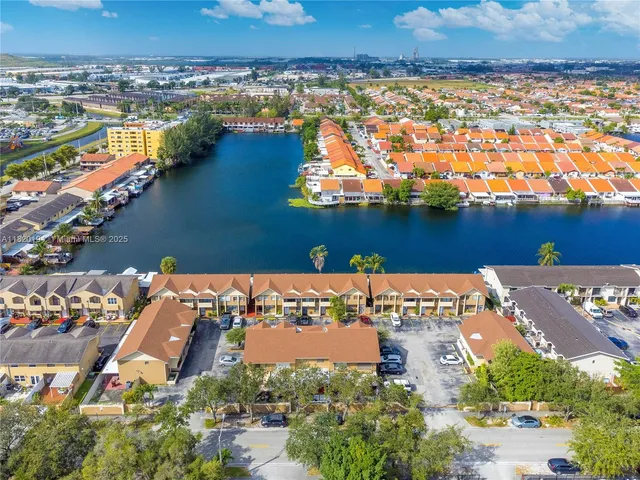 an aerial view of ocean and residential houses with outdoor space