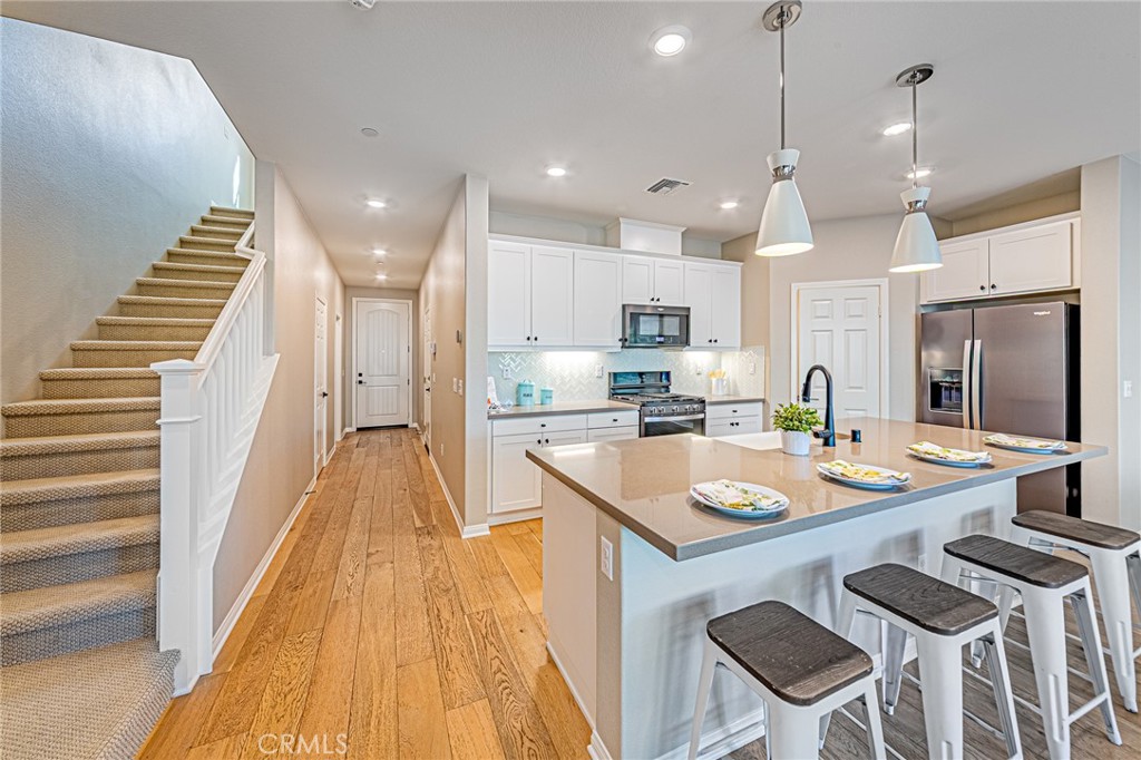1705 Almond Tree Place Upland, CA 91784 - Photo 7 of 41 a kitchen with granite countertop kitchen island stainless steel appliances sink stove and white cabinets