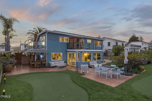 a view of house with a big yard and potted plants
