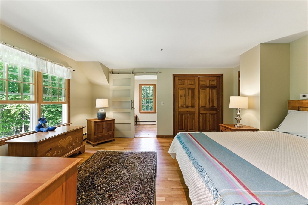 481 Kennedy Road Northampton, MA 01053 - Photo 20 of 40 a spacious bedroom with a balcony a large bed and a couch