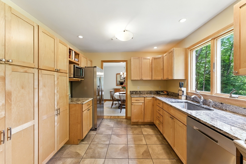 481 Kennedy Road Northampton, MA 01053 - Photo 7 of 40 a kitchen with stainless steel appliances granite countertop a refrigerator a sink dishwasher a stove and a refrigerator with wooden floor