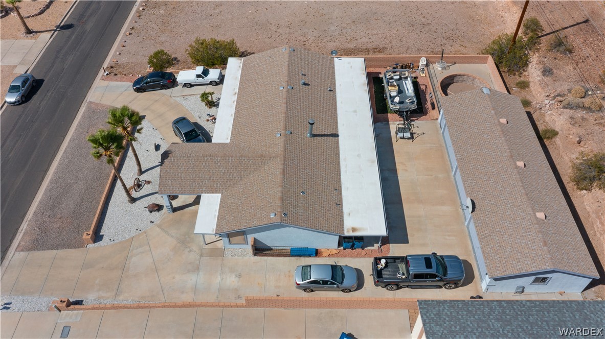 784 Pegasus Ranch Road Bullhead City, AZ 86429 - Photo 92 of 100 Single-story residence with a light-colored shingle roof, a detached garage structure, and a large concrete driveway