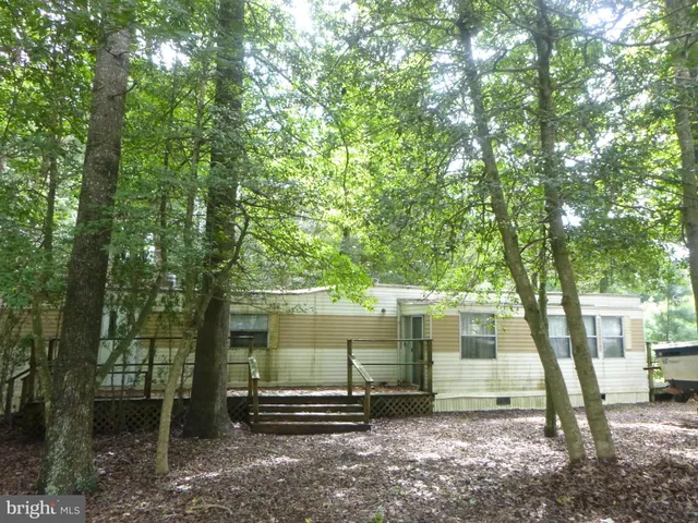 a view of a house with a tree in the forest
