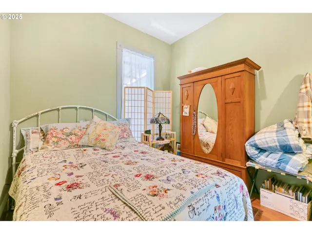 a bedroom with a large bed and wooden floor
