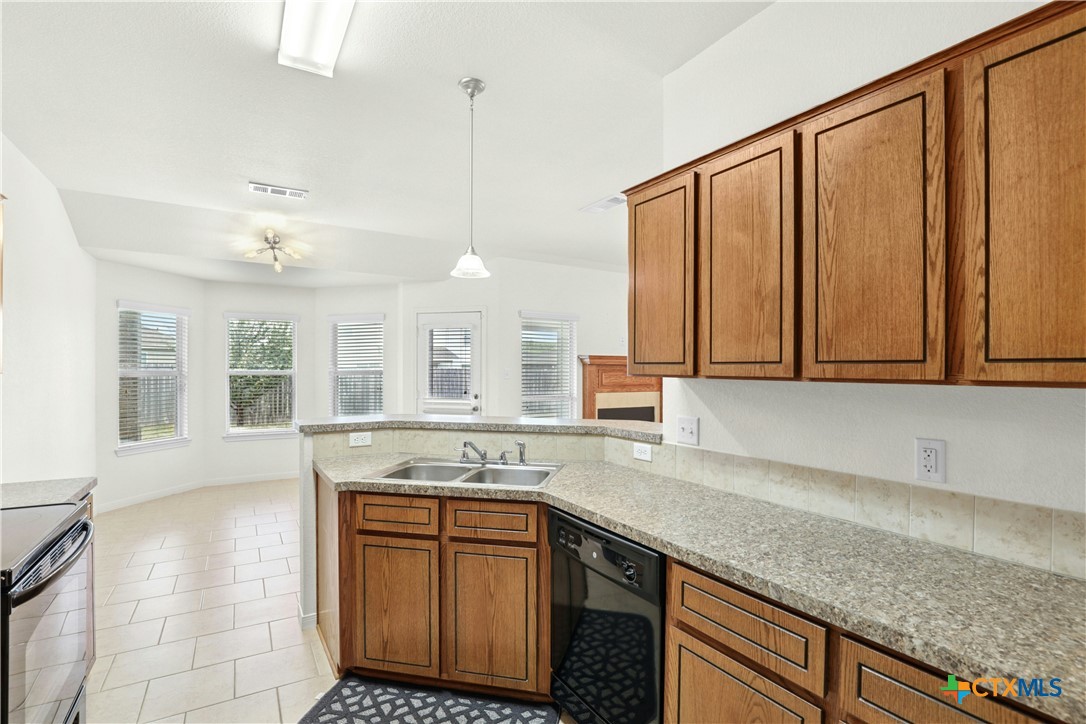 3203 Canadian River Loop Killeen, TX 76549 - Photo 13 of 27 a kitchen with stainless steel appliances granite countertop wooden cabinets a sink and dishwasher