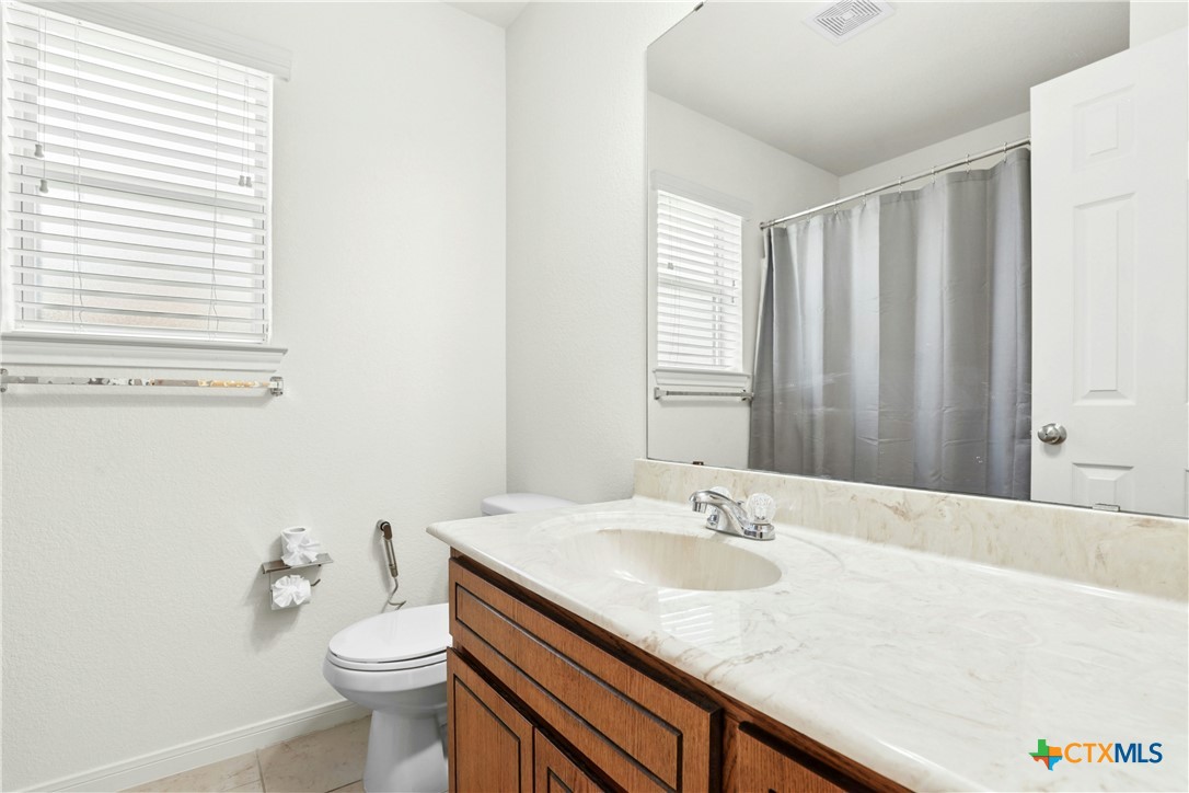 3203 Canadian River Loop Killeen, TX 76549 - Photo 21 of 27 a bathroom with a granite countertop sink and a toilet