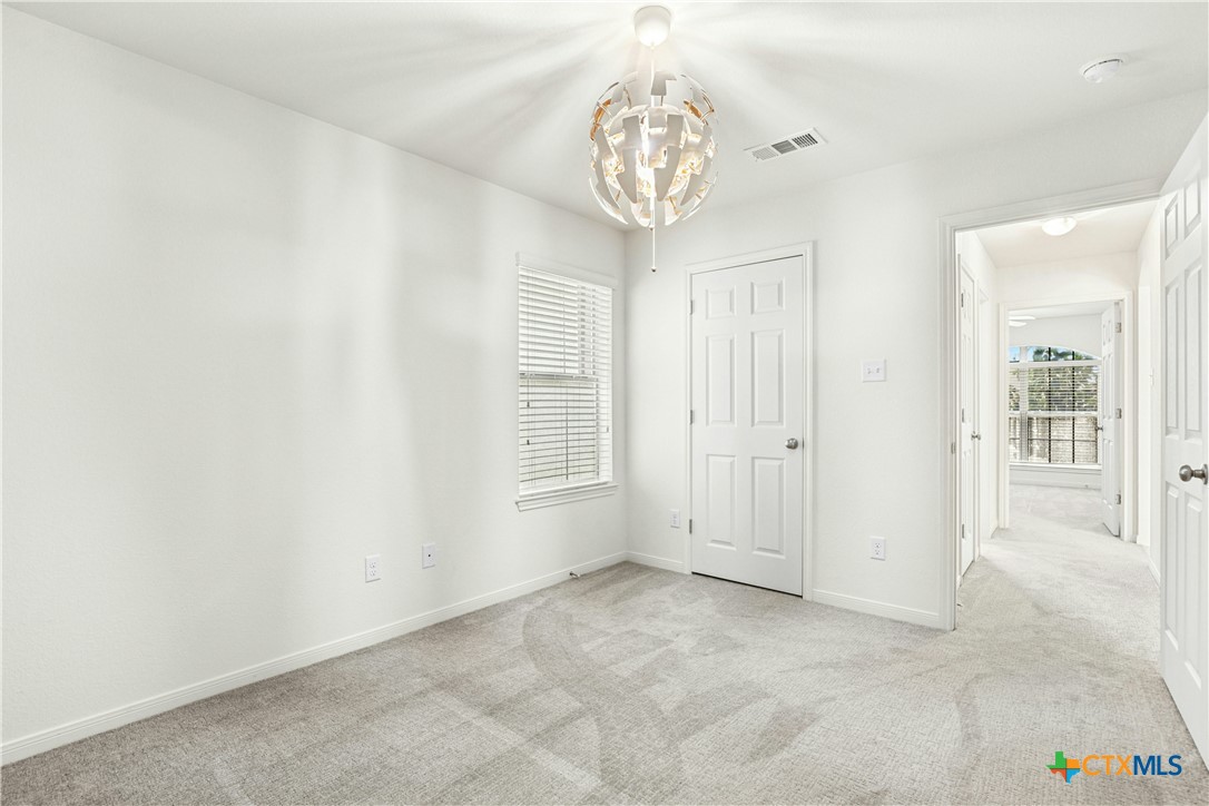 3203 Canadian River Loop Killeen, TX 76549 - Photo 23 of 27 an empty room with a chandelier fan