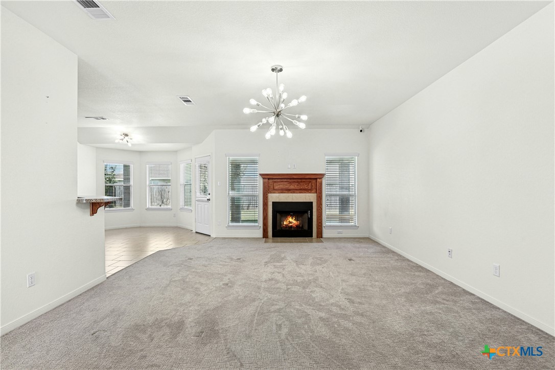 3203 Canadian River Loop Killeen, TX 76549 - Photo 7 of 27 an empty room with fireplace chandelier and windows
