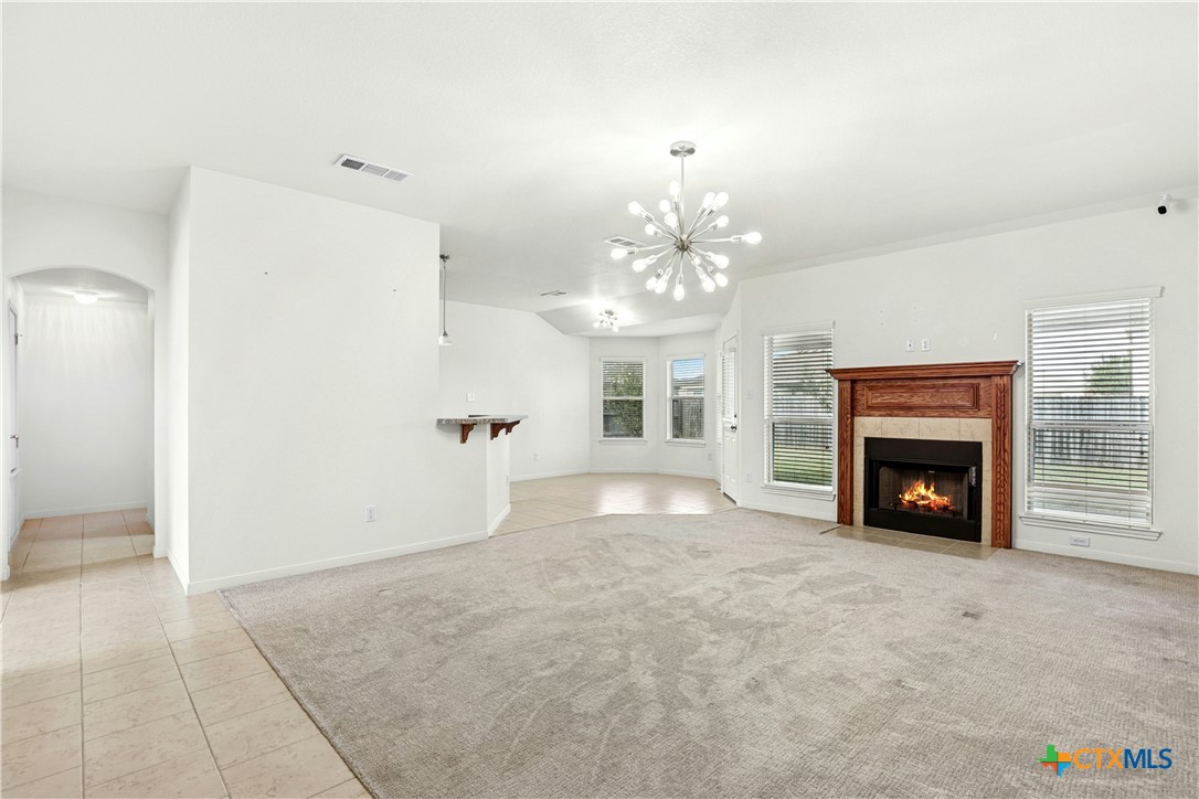 3203 Canadian River Loop Killeen, TX 76549 - Photo 8 of 27 a view of a livingroom with a fireplace a chandelier and a large window
