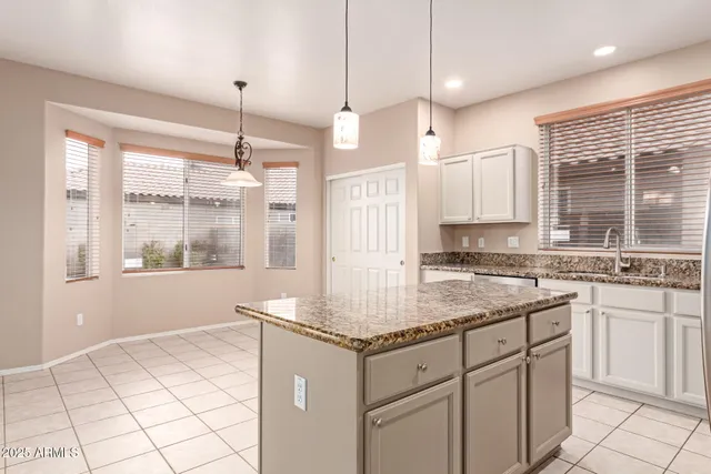 a kitchen with stainless steel appliances granite countertop a stove a sink and white cabinets with granite countertops