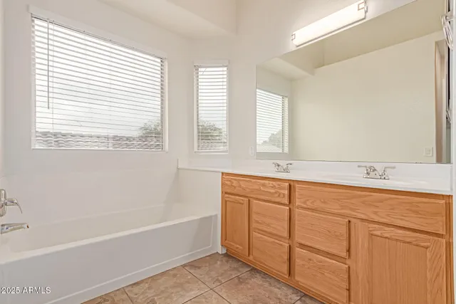 a bathroom with a tub sink and mirror