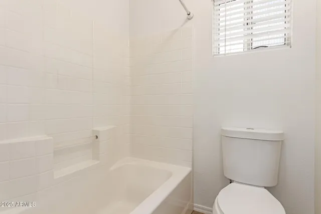 a white toilet sitting next to a bath tub