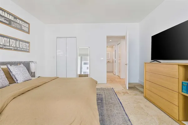 a bedroom with a bed and a flat screen tv