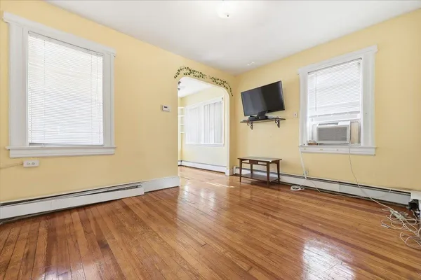a view of a room with wooden floor and a window