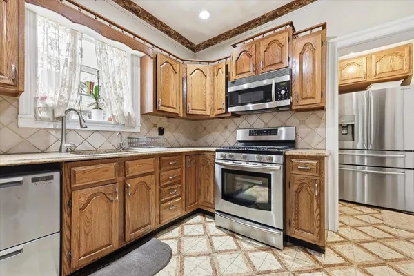 a kitchen with stainless steel appliances granite countertop a stove microwave and cabinets
