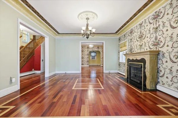 a view of a hallway with wooden floor staircase and a kitchen space