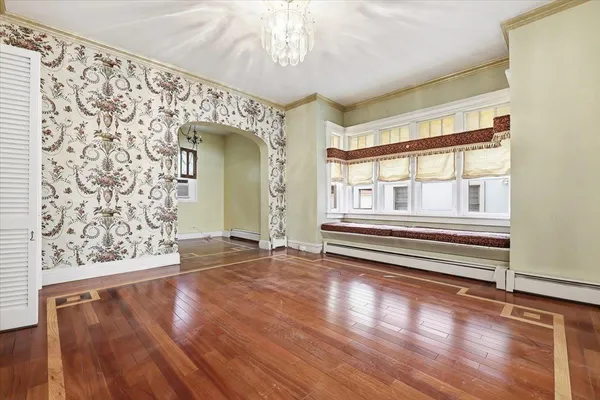 a view of a room with wooden floor and large windows