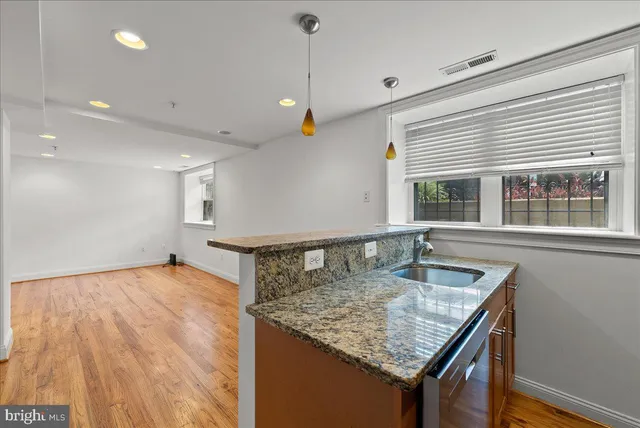 a kitchen with kitchen island a counter top space a sink and appliances