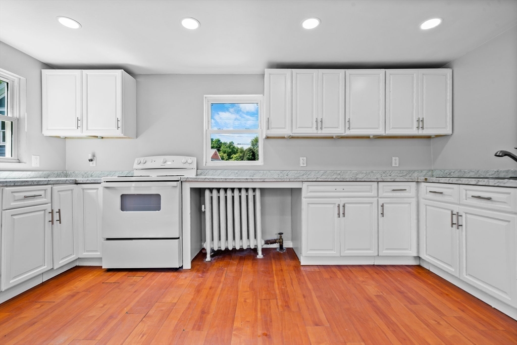 64 Pleasant Street Ware, MA 01082 - Photo 11 of 38 a kitchen with granite countertop white cabinets and white appliances