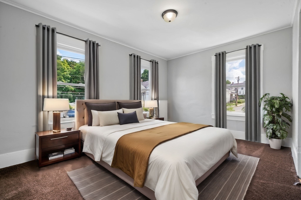 64 Pleasant Street Ware, MA 01082 - Photo 14 of 38 a bedroom with a large bed and a potted plant