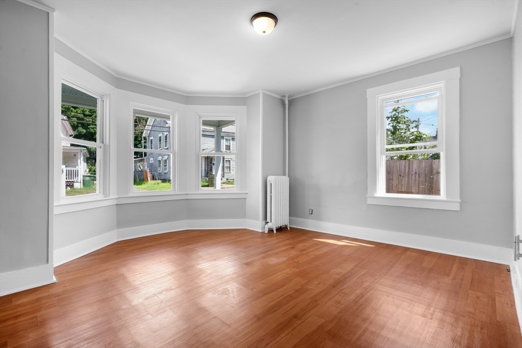 64 Pleasant Street Ware, MA 01082 - Photo 5 of 38 a view of an empty room with a window and wooden floor