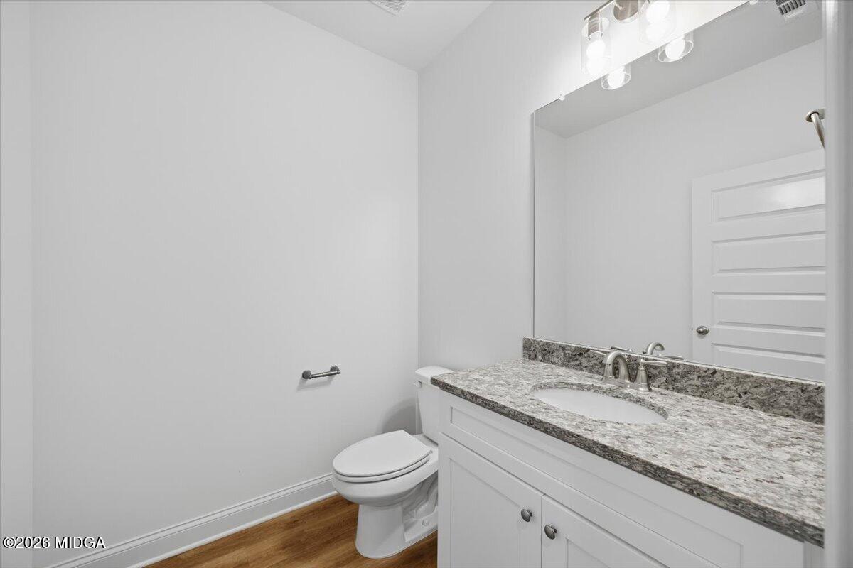 2762 Boxankle Road Forsyth, GA 31029 - Photo 12 of 19 a bathroom with a granite countertop sink a toilet and a mirror
