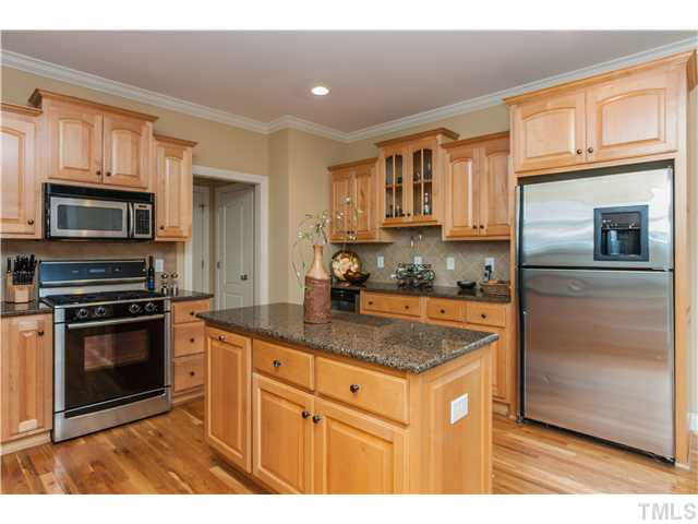 5820 Turner Store Lane Raleigh, NC 27603 - Photo 8 of 25 All appliances convey including Bosch gas range, built in microwave & extra capacity stainless refrig. Island w/wood side panels & addtl under counter storage and trash cabinet. Shown at back - butlers pantry which includes glass doors & wine refrigerator