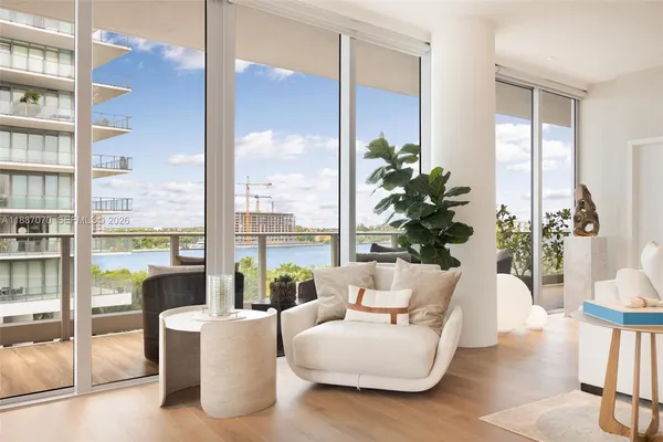 a living room with furniture fireplace and a large window