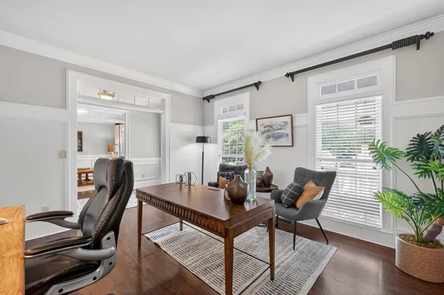 a living room with furniture a chandelier and wooden floor