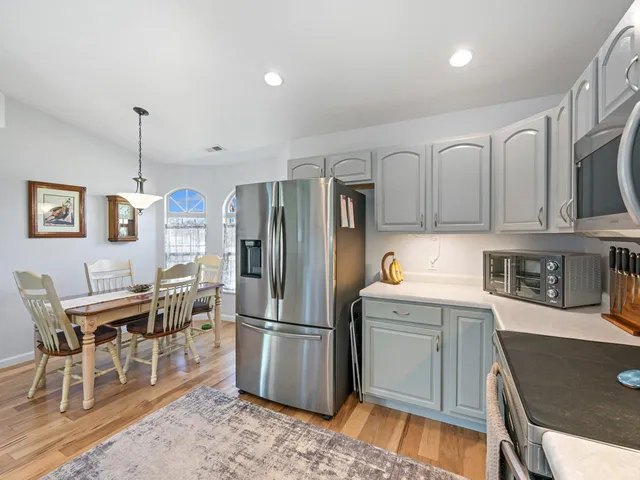 a kitchen with stainless steel appliances granite countertop a refrigerator and a stove top oven