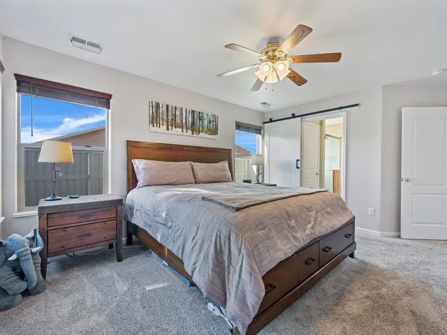 a spacious bedroom with a bed and a chandelier