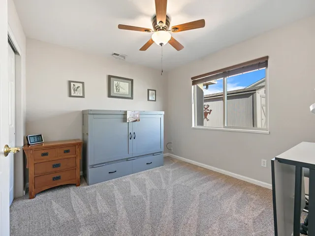 a bedroom with a bed and a ceiling fan