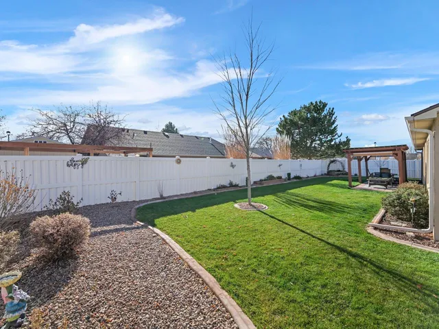 an view of a house with a yard and wooden fence