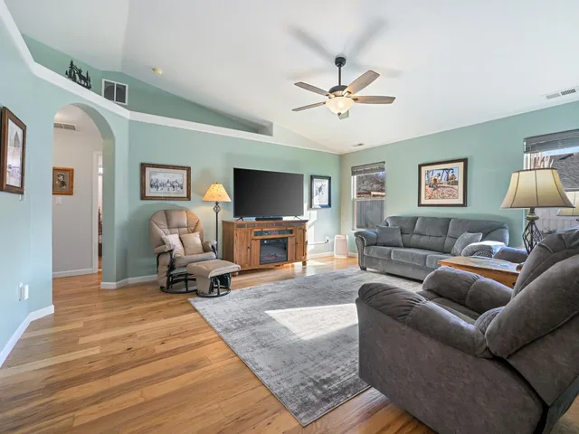 a living room with furniture a ceiling fan and a rug