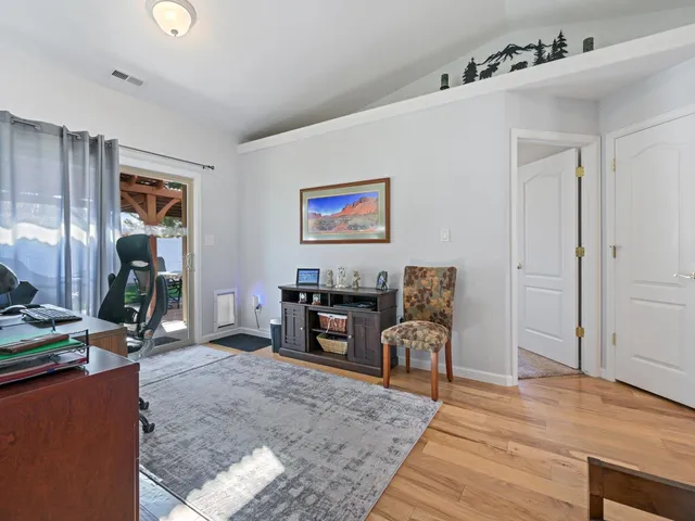 a view of a workspace with furniture and wooden floor