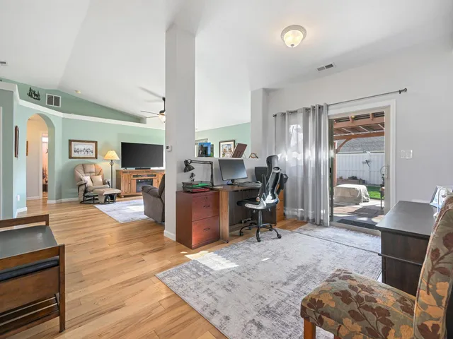 a work room with furniture a rug and a window