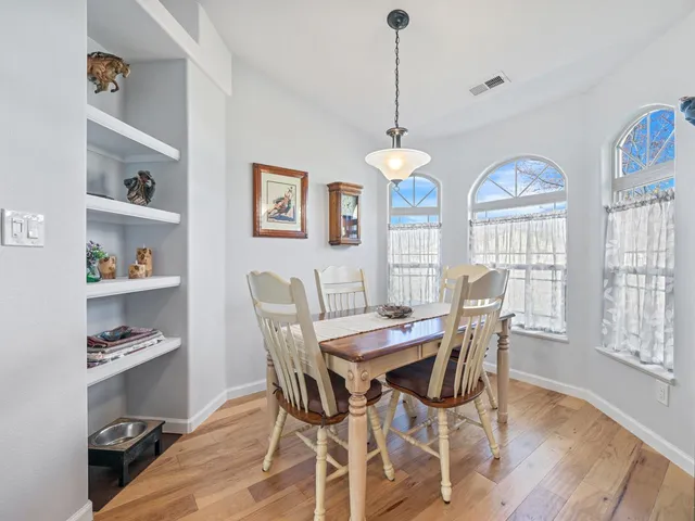 a view of a dining room with furniture a chandelier and wooden floor