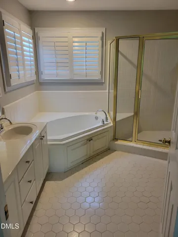 a bathroom with a tub sink and mirror