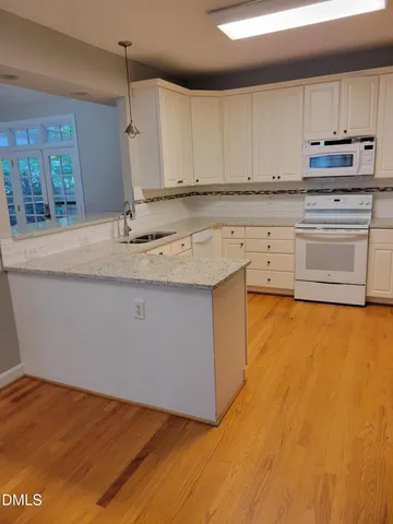 a kitchen with stainless steel appliances granite countertop a sink a stove top oven a counter space and cabinets