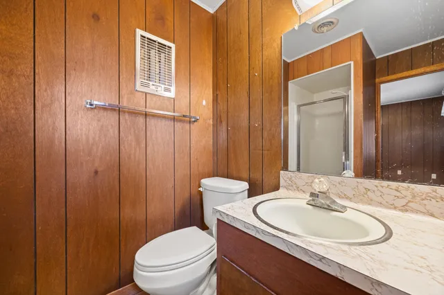 a bathroom with a toilet a sink and mirror