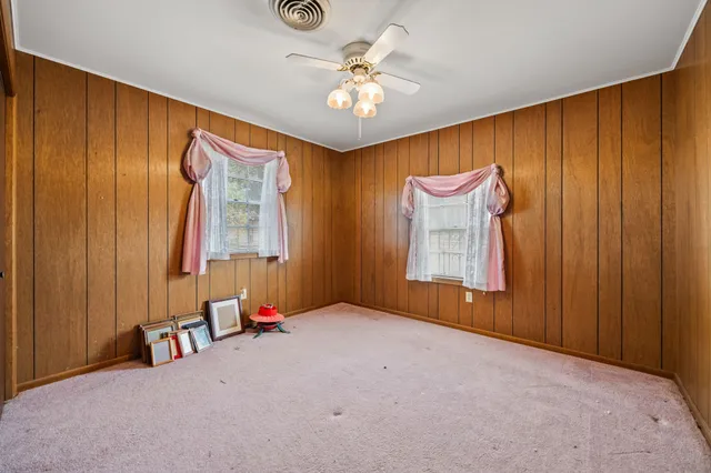 an empty room with windows and closet area
