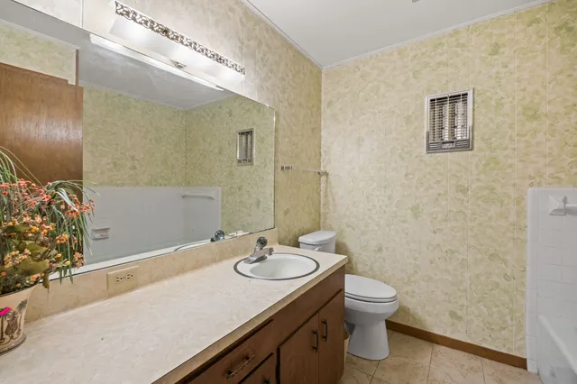 a bathroom with a granite countertop sink toilet and a mirror